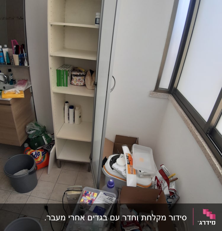 ארון פתוח עם מדפים, קופסאות ופריטים לארגון